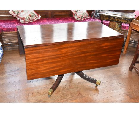 A circa 1900 Mahogany single pedestal drop-leaf Dining Table standing on a heavy turned pillar having four elegant swept feet