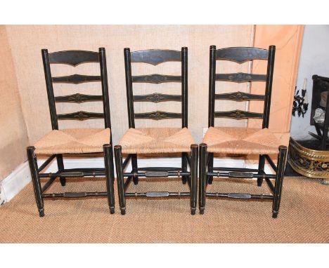 Three black lacquered ladder-back Dining Chairs darkly decorated with stylised flower blooms and having woven seagrass seats.