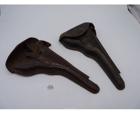 A pair of leather pistol holders, each containing a spanner/turnkey to the lid and a cleaning rod and measuring 14'' long ove