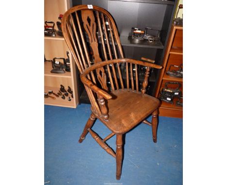 A solid Elm seated stick-back open armed kitchen carver chair having a fret-worked centre back-splat, bentwood arms with turn