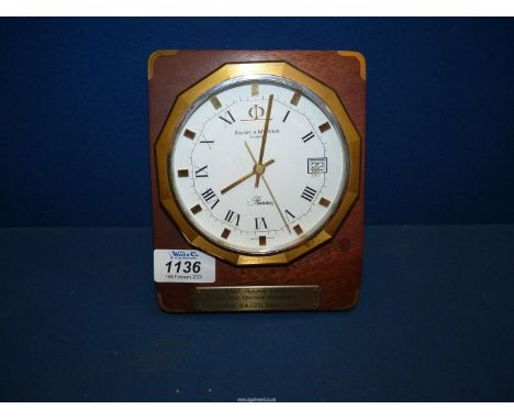 A Baume &amp; Mercier Riviera desk clock on wooden plinth with presentation plaque.