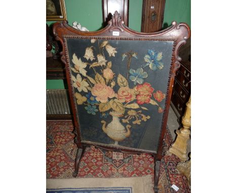 A large Oak framed Firescreen having shaped perimiter and scroll feet with foliage detail, the panel depicting a gros-point w