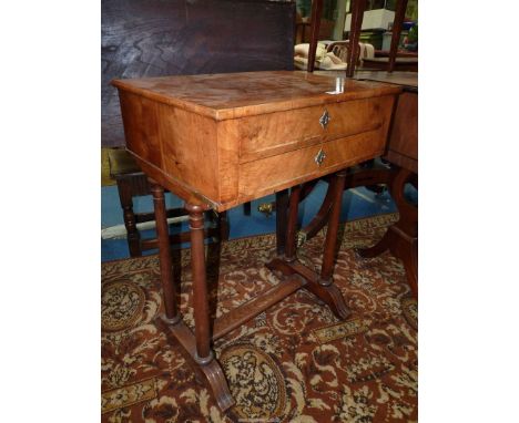 A Walnut and other woods Workbox Table having two drawers and raised on four turned pillar supports, the feet united by a cen