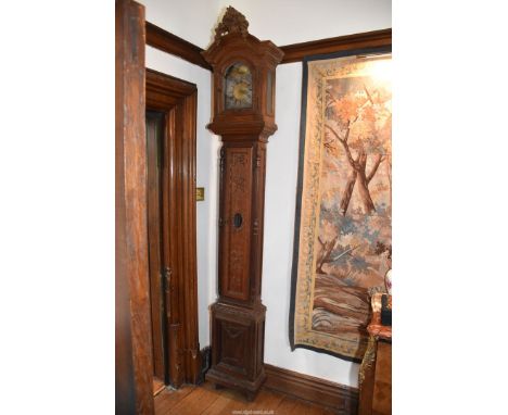 An unusually slender Oak cased long-case Clock, the case decorated in relief with bows and swags, a torch and a quiver of arr