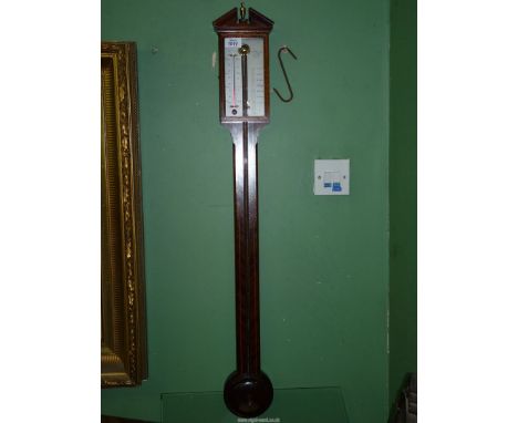 A stick Barometer by Comitti and Sons London in Mahogany and boxwood having broken arch design pediment and grey metal dial, 