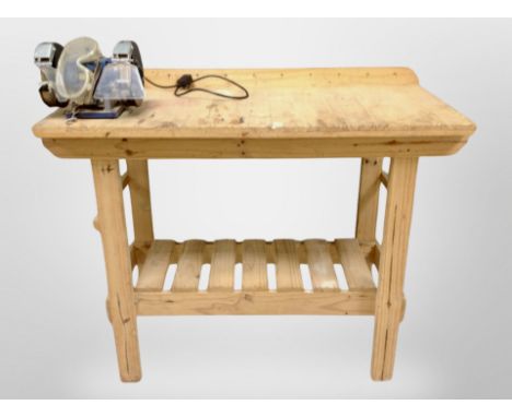 An early 20th century pine work shop bench fitted with a disc grinder, width 117 cm 