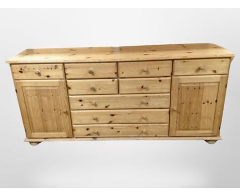A contemporary pine sideboard fitted cupboards and drawers, length 177cm.