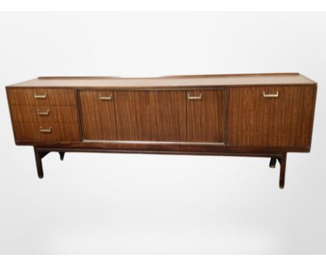 A 1970's teak low sideboard, fitted cupboards and drawers, length 221 cm 