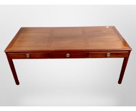A reproduction mahogany low coffee table, fitted three drawers, width 135 cm 