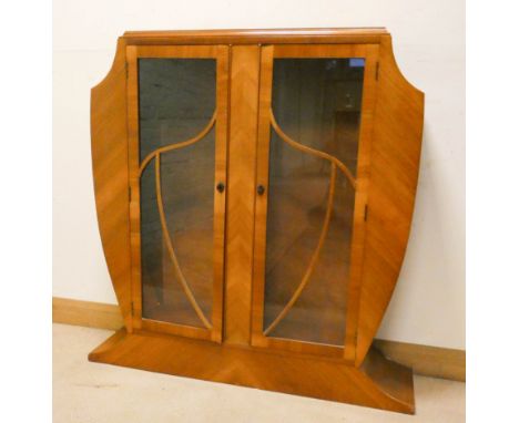 A 1930s Art Deco style shaped walnut two door glazed display cabinet, 45" wide