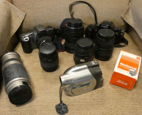 Two cannon cameras with various lenses together with a Panasonic stereo zoom DVD video camera, all with a carrying case 