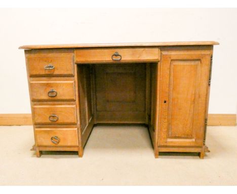 An early 20th century light oak desk double pedestals each fitted four drawers and a drawer to the centre with three carved p