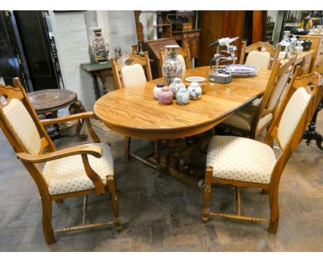 A heavy light oak oval refectory style dining table with fold away centre leaf and five matching dining room chairs with crea