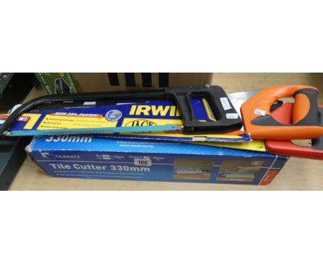 A tile cutter, two hand saws and a hacksaw 