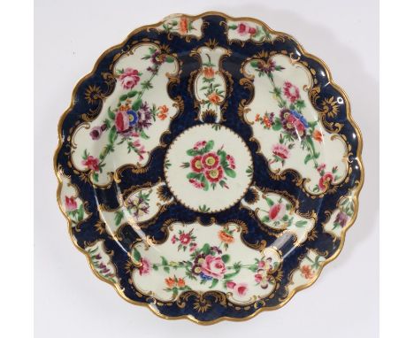 Worcester porcelain scale pattern plate, circa 1775, painted with flora within gilded cartouches on a blue scale ground, hatc