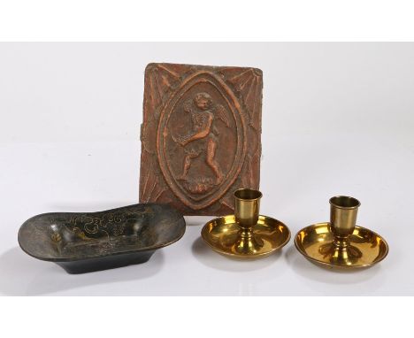Three objects, to include a brass Brighton bun candlestick, a Regency papier mache dish and a 19th Century tile with cupid to