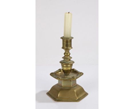 Brass candlestick, with a stepped stem and faces to the sconce edge above the arched base, 18cm high