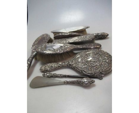 A collection of silver backed dressing table items including a mirror, hairbrushes and clothes brushes, button hook, shoe hor