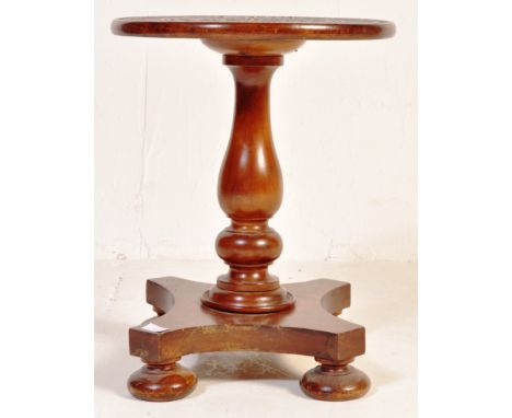 A Victorian 19th century mahogany side table of pedestal form. The table being raised on a quadruped base with bun feet havin