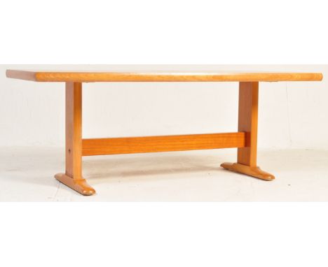 A retro vintage mid 20th century teak wood coffee table of rectangular form having cross banded edges raised on upright suppo