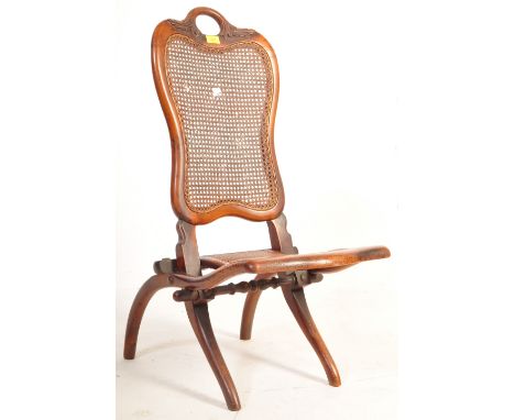 An early 20th century circa. 1930s campaign / steamer oak folding chair having a carved oak frame with cane back rest and sea