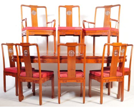 A 20th century Chinese Oriental hardwood extendable dining table and chairs having geometric pattern to the table top raised 