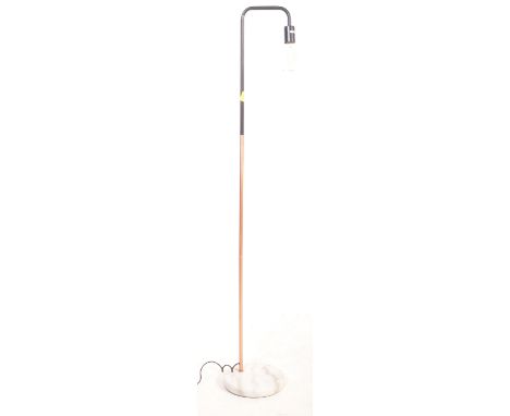 A retro vintage style floor standing standard lamp having a single copper and black support raised on a&nbsp; circular white 