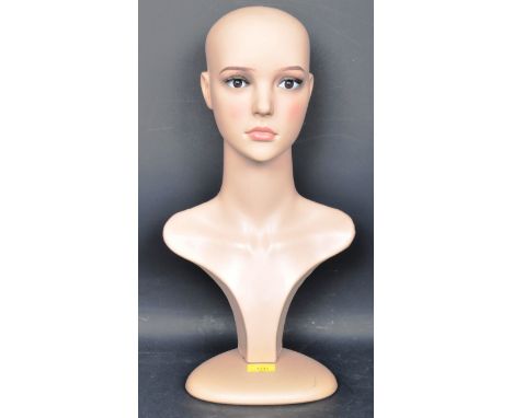 A contemporary plastic milliners bust / shop display mannequin dummy having naturalistic facial detailing raised on a triangu