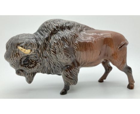 A Beswick ceramic bison figure #1019 in brown gloss finish, with circular backstamp. Approx. 13.5cm tall x 24cm long. 