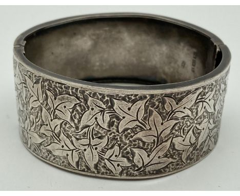 A Victorian silver wide bangle with ivy leaf engraved design to one half and push clasp. Hallmarked for Blanckensee &amp; Lev