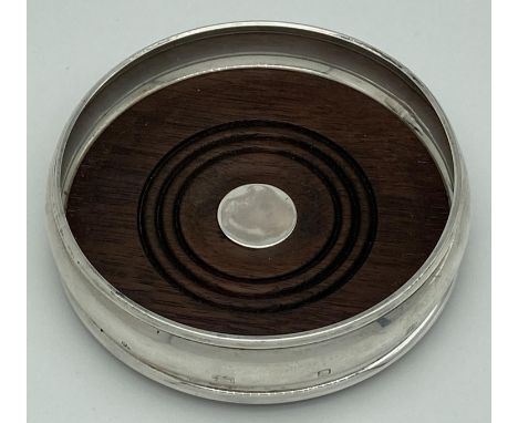 A curve sided silver wine coaster, hallmarked M. C. Hersey &amp; Son Ltd, London 1990. With dark wood base and green baize un