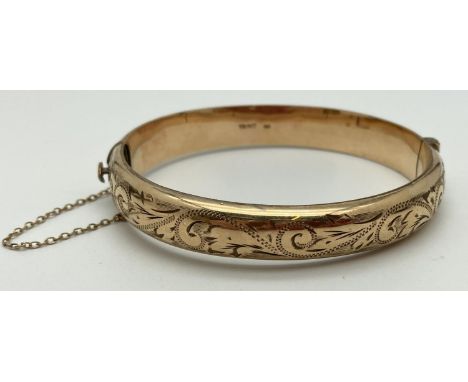 A vintage rolled gold bangle with safety chain, push clasp and half engraved floral decoration. Inside of bangle marked "1/6t