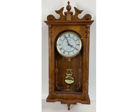 A modern wooden cased wall hanging Acctim quartz Westminster chime clock. With glass front panel, complete with pendulum. In 