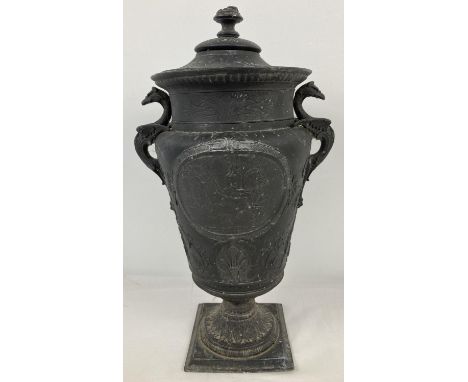 A vintage cast metal lidded urn with horse and rider decorated panel to front and back, floral detail throughout and Griffin 