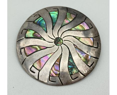 A vintage Mexican silver circular brooch with swirl design, set with paua shell. Silver marks to back of brooch. Approx. 4.5c