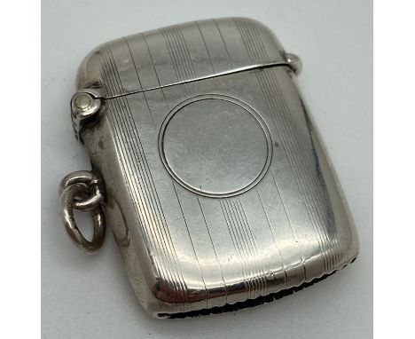 An early 20th century silver vesta case with engine turned detail and circular empty cartouche. Hallmarked W. J. Myatt &amp; 