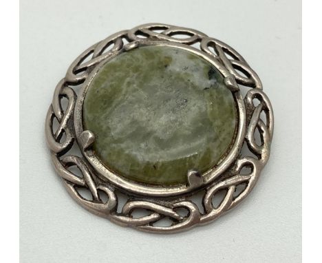 A vintage Celtic pierced work brooch set with a round green agate stone. Silver marks to reverse. Year date Z indistinct assa