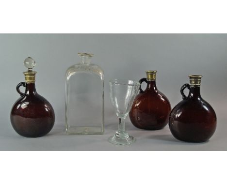 Three brass mounted brown glass decanters, late 19th century, of bellied form with ring handles, one with associated stopper,