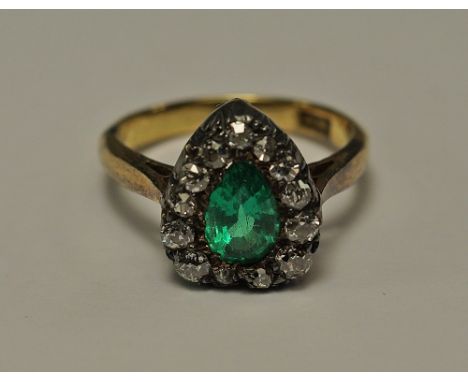 An 18ct gold, emerald and diamond heart shape ring, the pear cut emerald surrounded by old cut diamonds, approx size H/I, app