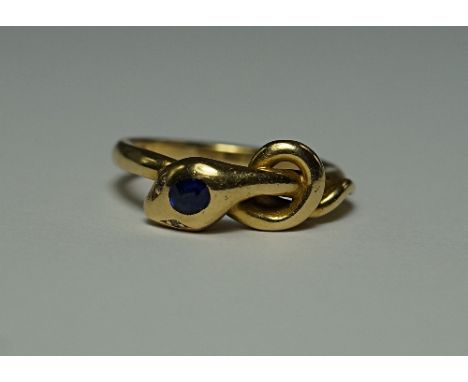 An 18ct gold snake ring, the serpent with diamond chip eyes and an oval cut sapphire to the head, approx size M/N, approx 5.4