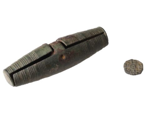 Anglo-Saxon, early 8th century, a tubular bronze money box of biconical cylindrical shape moulded in two halves which are hin