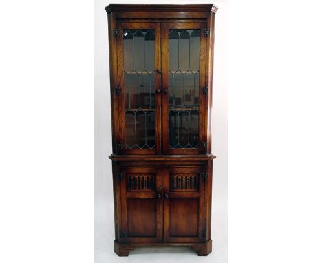 Georgian style oak double corner cupboard, the upper section with glazed leaded light panel doors, enclosing shelves, with a 