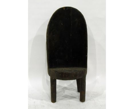 Nagaland chief's chair hollowed from a tree trunk, the back carved with coiled serpents, skull, etc, on short turned supports