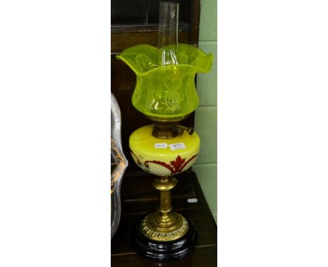 A Victorian oil lamp with yellow reservoir and shade