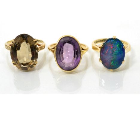 A 9 carat gold opal triplet ring, an oval cabochon opal triplet in a claw setting, to tapered shoulders, finger size M; a 9 c