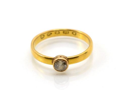 A 22 carat gold solitaire diamond ring, an old cut diamond in a rubbed over setting, to straight shoulders, estimated diamond