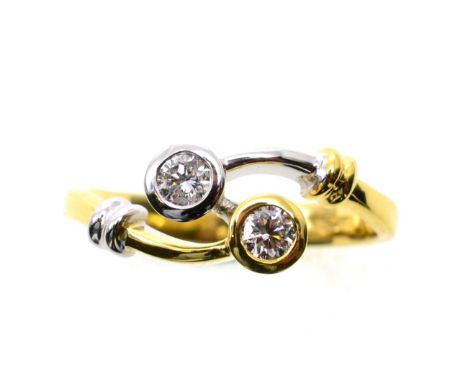 An 18 carat two colour gold diamond ring, two round brilliant cut diamonds in rubbed over settings, to white and yellow gold 