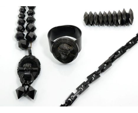 A Victorian jet pendant necklace, an oval jet pendant, carved in high relief, with two faceted drops and suspended from a nec