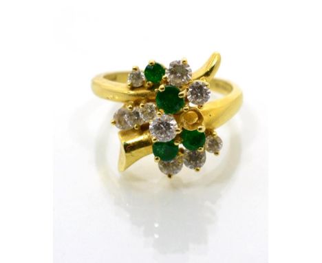 An 18 carat gold emerald and diamond ring, vari-sized round brilliant cut diamonds and round cut emeralds in claw settings, t