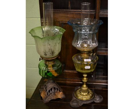 An oil lamp with spelter base, green glass reservoir and shade, together with another oil lamp